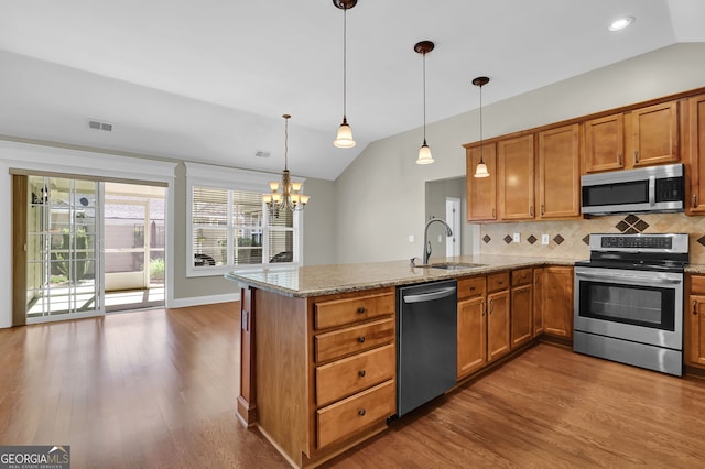 308 Jessica Way, Canton, GA 30114 - kitchen featuring appliances with stainless steel finishes, a sink, a peninsula, lofted ceiling, and decorative backsplash