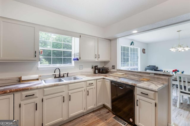 40 Carole Dr, Carrollton, GA 30117 - kitchen with a sink, a peninsula, dishwasher, light countertops, and light wood-style floors