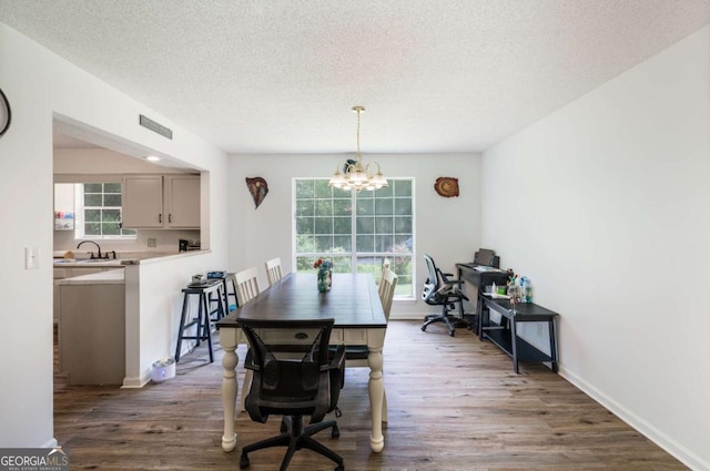 40 Carole Dr, Carrollton, GA 30117 - dining area featuring a textured ceiling, baseboards, an inviting chandelier, visible vents, and wood finished floors