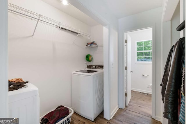 40 Carole Dr, Carrollton, GA 30117 - laundry area with light wood-style flooring, laundry area, washer and clothes dryer, visible vents, and baseboards