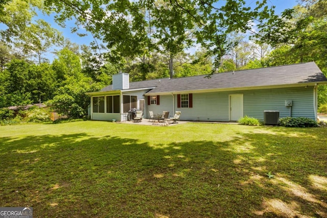 40 Carole Dr, Carrollton, GA 30117 - rear view of house featuring a sunroom, a chimney, a lawn, central air condition unit, and a patio area