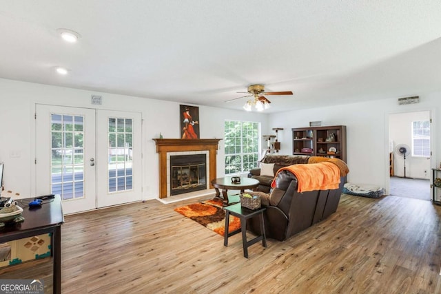 40 Carole Dr, Carrollton, GA 30117 - living room featuring french doors, a ceiling fan, light wood-type flooring, a glass covered fireplace, and recessed lighting