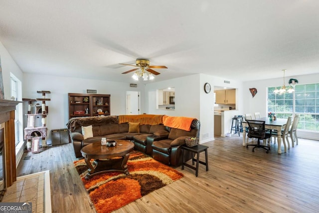 40 Carole Dr, Carrollton, GA 30117 - living area featuring a fireplace, light wood finished floors, ceiling fan with notable chandelier, and baseboards