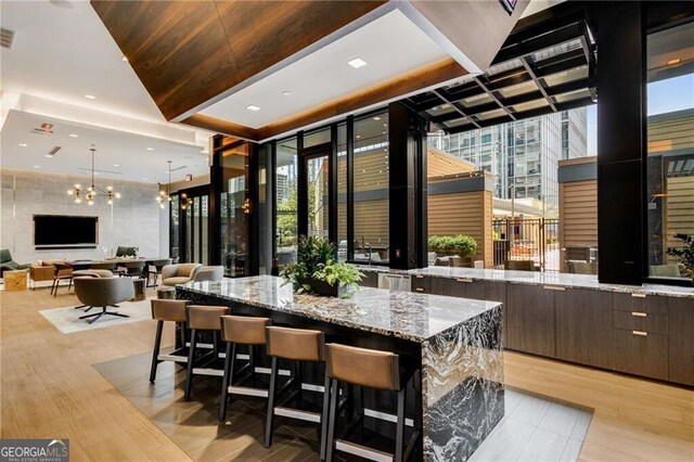 40 12th St NE Unit 803, Atlanta, GA 30309 - bar with pendant lighting, a wealth of natural light, light wood-type flooring, and visible vents
