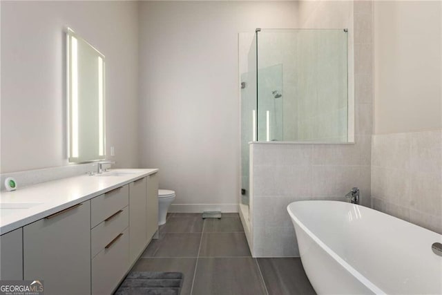 40 12th St NE Unit 803, Atlanta, GA 30309 - full bath featuring double vanity, a tile shower, a sink, a freestanding bath, and tile patterned flooring