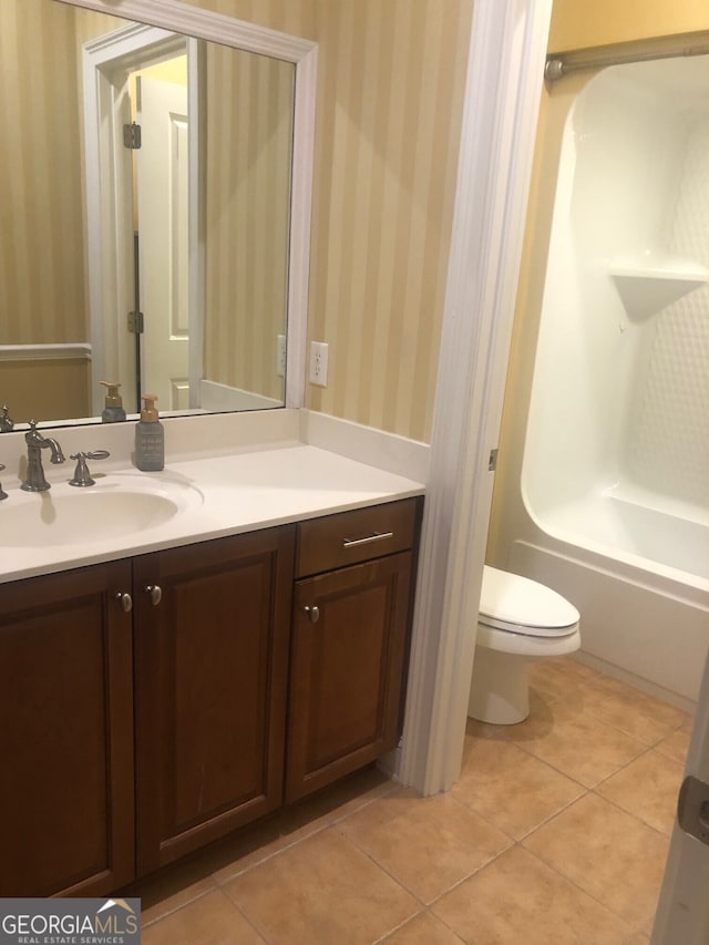 full bathroom with toilet, wallpapered walls, shower / bath combination, tile patterned floors, and vanity