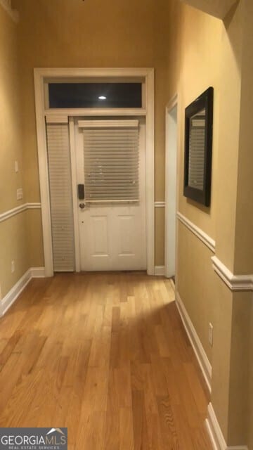 doorway to outside featuring baseboards and light wood-style floors