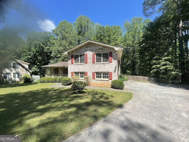 tri-level home featuring brick siding, covered porch, and driveway