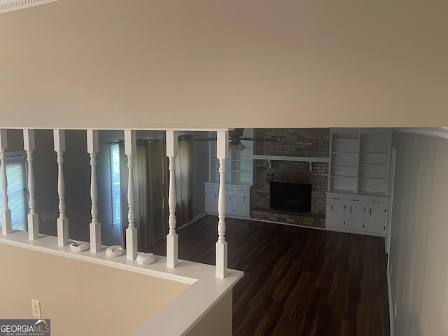 detailed view of wood finished floors, ceiling fan, and a stone fireplace