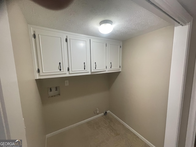 laundry room featuring washer hookup, baseboards, cabinet space, a textured ceiling, and gas dryer hookup