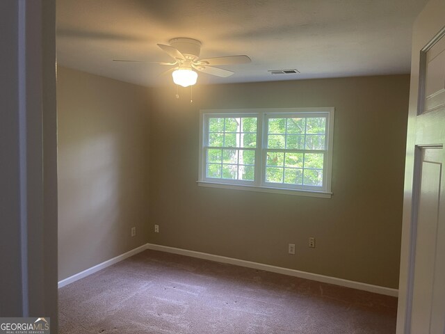 carpeted spare room with ceiling fan and baseboards