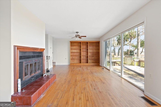 863 Hickory Bluff Rd, Waverly, GA 31565 - unfurnished living room featuring a tile fireplace, light wood finished floors, visible vents, baseboards, and built in features