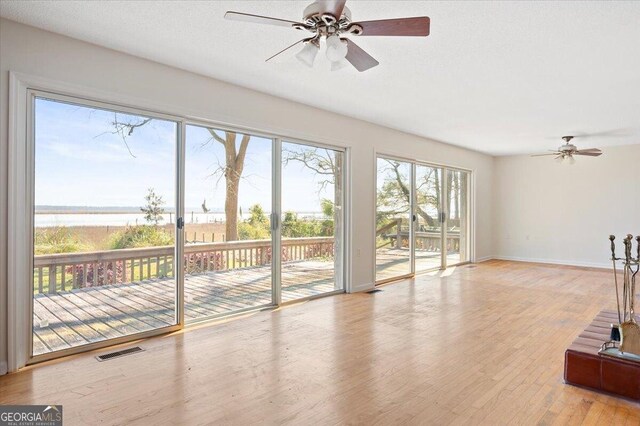 863 Hickory Bluff Rd, Waverly, GA 31565 - unfurnished living room featuring a healthy amount of sunlight, a ceiling fan, and visible vents