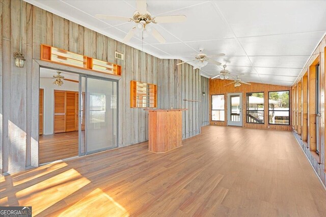863 Hickory Bluff Rd, Waverly, GA 31565 - interior space with a ceiling fan, visible vents, wood walls, vaulted ceiling, and light wood-type flooring