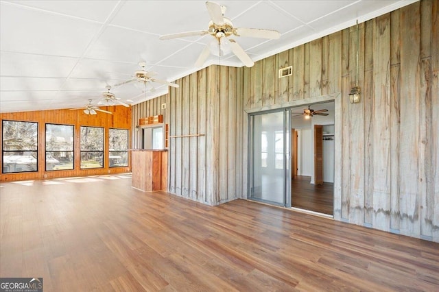 863 Hickory Bluff Rd, Waverly, GA 31565 - unfurnished living room featuring a wealth of natural light, wood walls, visible vents, and wood finished floors