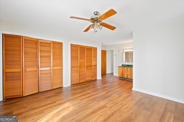 863 Hickory Bluff Rd, Waverly, GA 31565 - unfurnished bedroom with light wood finished floors, baseboards, a ceiling fan, and multiple closets