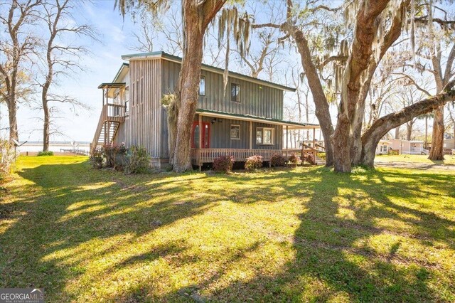 863 Hickory Bluff Rd, Waverly, GA 31565 - back of property featuring a yard, covered porch, and board and batten siding