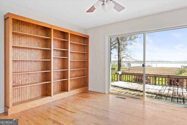 863 Hickory Bluff Rd, Waverly, GA 31565 - interior space featuring a ceiling fan, baseboards, visible vents, a water view, and wood finished floors