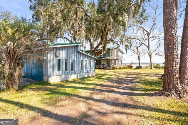863 Hickory Bluff Rd, Waverly, GA 31565 - view of home's exterior with board and batten siding and a lawn