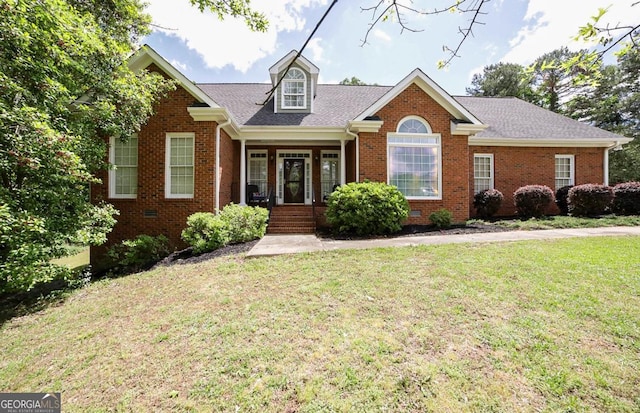 cape cod house with roof with shingles, brick siding, and a front lawn