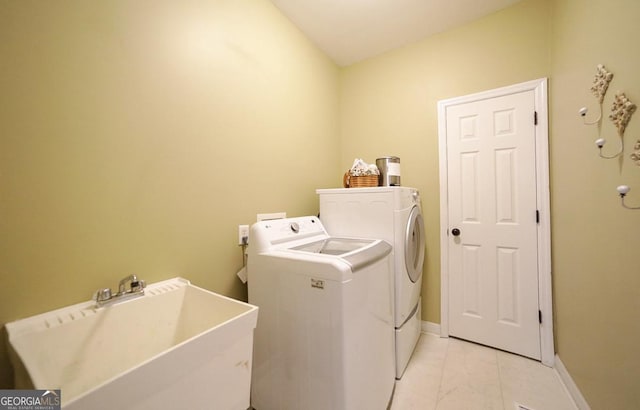 washroom featuring washer and clothes dryer, a sink, marble finish floor, laundry area, and baseboards
