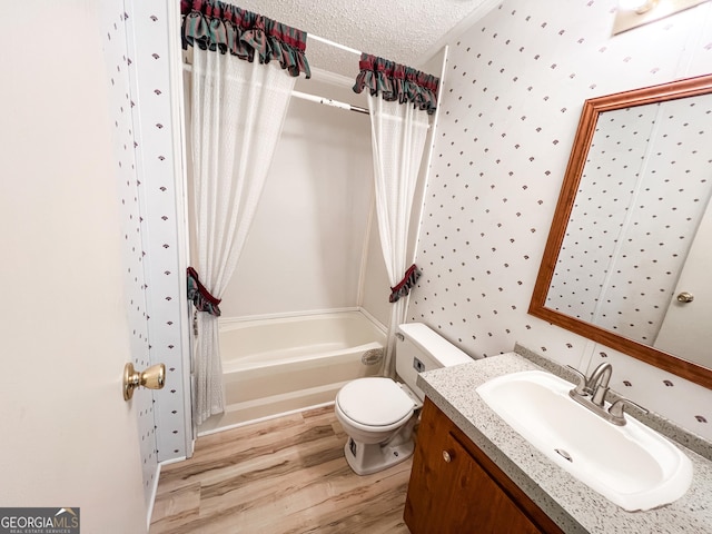 full bathroom featuring wallpapered walls, toilet, vanity, wood finished floors, and shower / bath combo