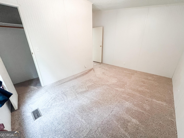 unfurnished bedroom with visible vents and carpet