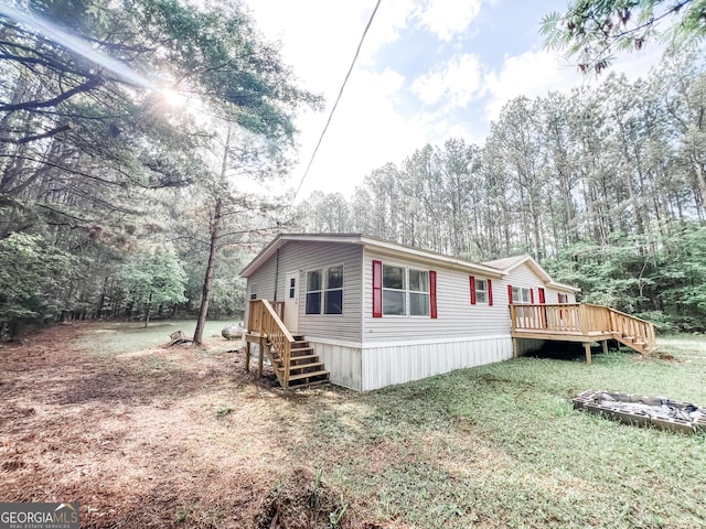 view of side of property featuring a lawn and a wooden deck