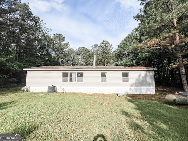 back of house featuring a yard and central AC unit