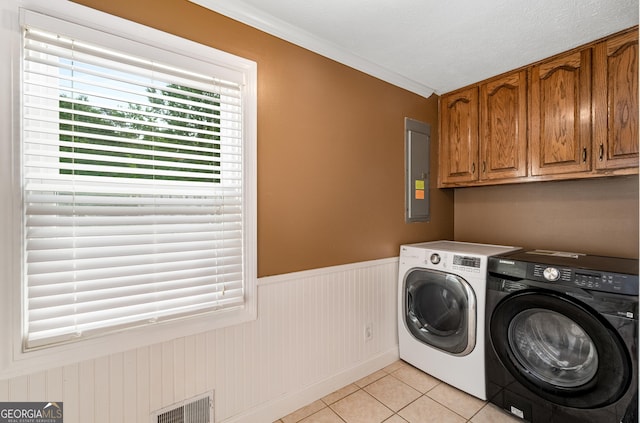 washroom with light tile patterned floors, a healthy amount of sunlight, a wainscoted wall, electric panel, and washer and clothes dryer