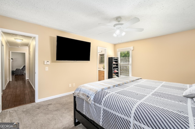 carpeted bedroom featuring baseboards, ceiling fan, and a textured ceiling