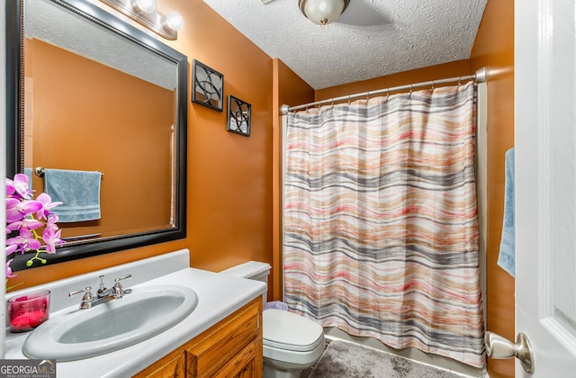 full bathroom featuring toilet, shower / tub combo with curtain, vanity, and a textured ceiling