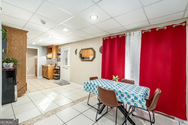 dining space featuring a drop ceiling, baseboards, light tile patterned floors, and recessed lighting