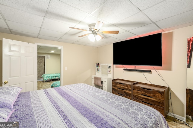 bedroom featuring a drop ceiling and a ceiling fan