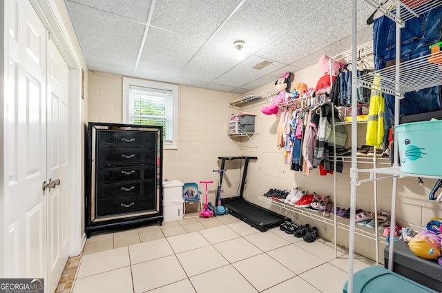 interior space with tile patterned floors and concrete block wall