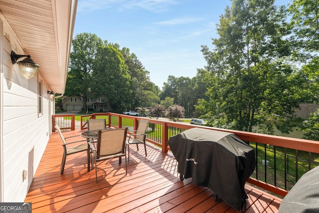 wooden terrace with a grill and outdoor dining space