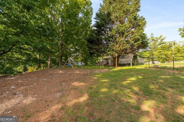 view of yard featuring fence and a playground