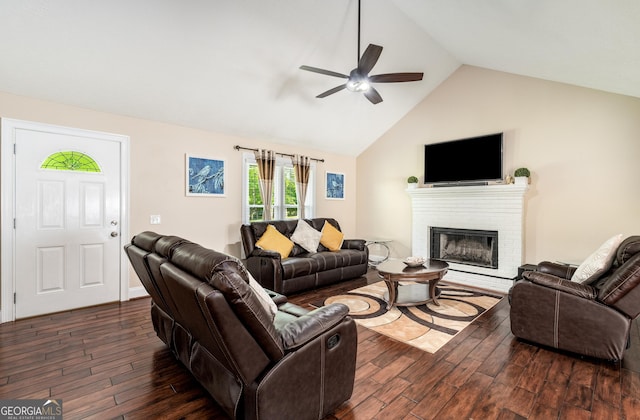 living room with vaulted ceiling, ceiling fan, a fireplace, and dark wood-style floors