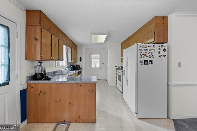 873 Austin Rd, Newnan, GA 30263 - kitchen with white appliances, a peninsula, light floors, brown cabinetry, and baseboards