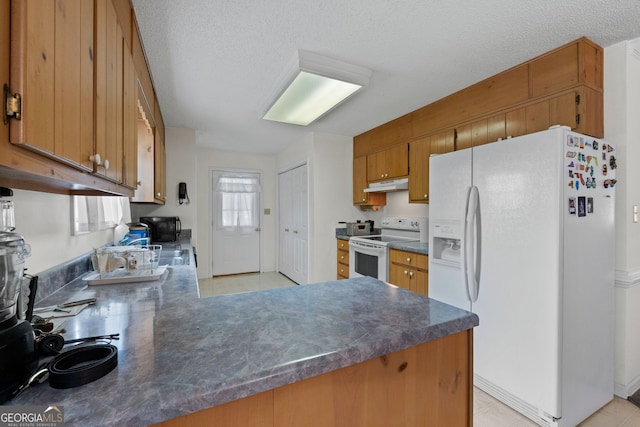 873 Austin Rd, Newnan, GA 30263 - kitchen with white appliances, brown cabinetry, a peninsula, dark countertops, and a textured ceiling
