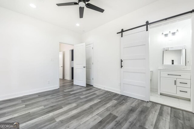 2349 Berthadale Ave, Macon, GA 31204 - unfurnished bedroom with light wood-style flooring, a barn door, baseboards, and recessed lighting