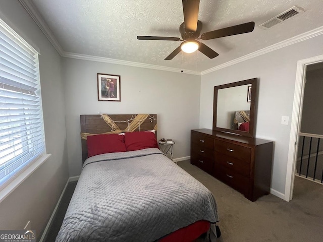 carpeted bedroom featuring crown molding, visible vents, baseboards, and a ceiling fan