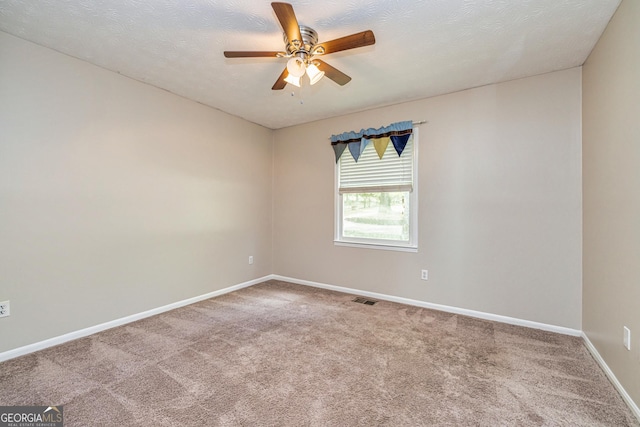 carpeted empty room with a ceiling fan, baseboards, visible vents, and a textured ceiling