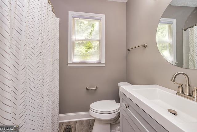 full bath with toilet, vanity, plenty of natural light, and wood finished floors