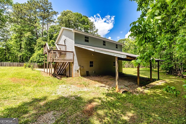 back of property featuring a lawn, stairway, fence, and a wooden deck