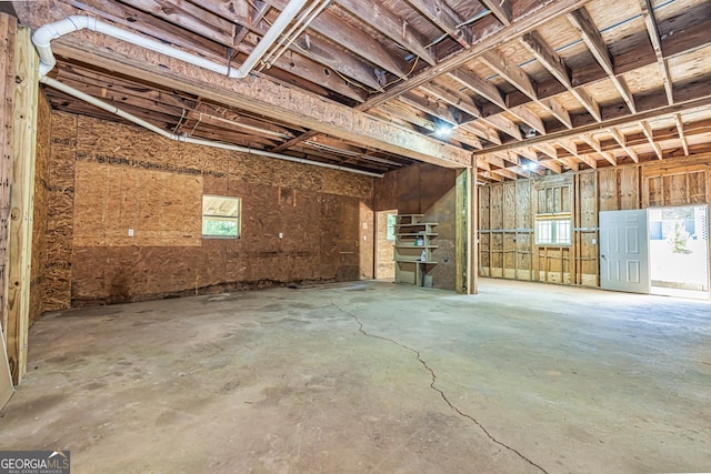 miscellaneous room with unfinished concrete floors and a garage