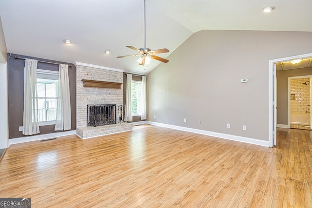 unfurnished living room with light wood-style flooring, a brick fireplace, visible vents, ceiling fan, and vaulted ceiling