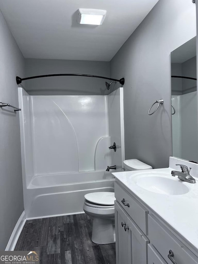 bathroom with toilet, washtub / shower combination, vanity, and wood finished floors