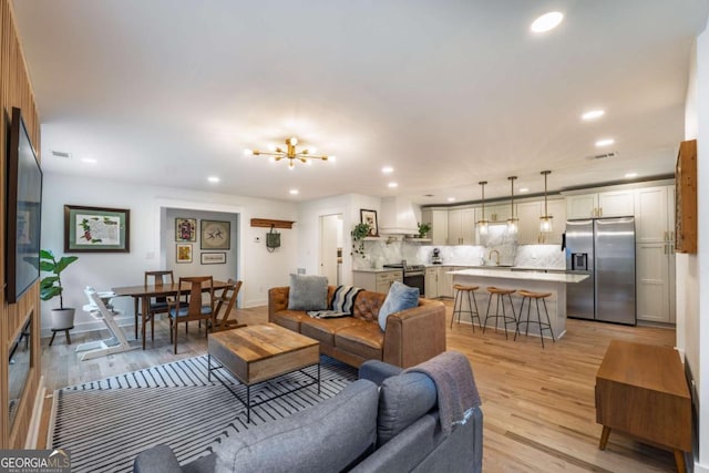 82 Dearborn St SE, Atlanta, GA 30317 - living room featuring light wood-type flooring, a chandelier, recessed lighting, and baseboards