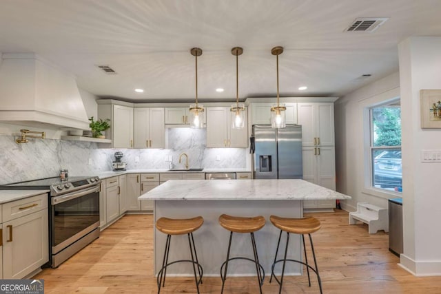 82 Dearborn St SE, Atlanta, GA 30317 - kitchen featuring appliances with stainless steel finishes, a kitchen island, a sink, a kitchen bar, and decorative backsplash